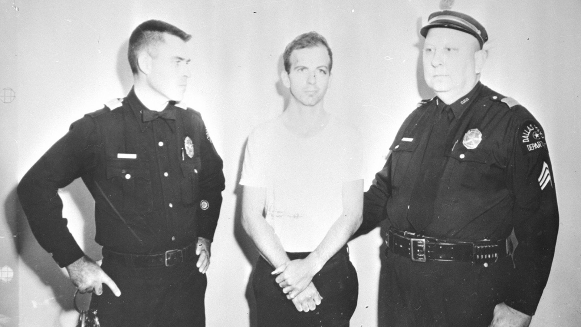 Photograph of Lee Harvey Oswald and two policemen taken after Oswald's arrest