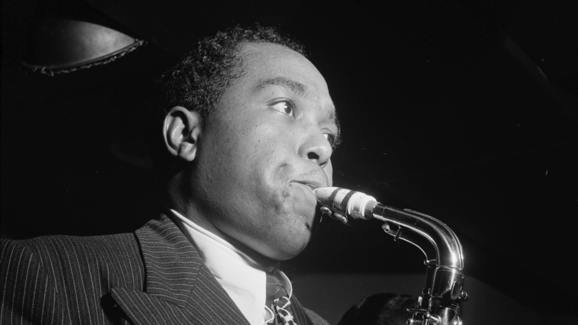 Portrait of Charlie Parker in the Three Deuces of New York (N.Y.), in August 1947. Parker is playing a Conn 6M alto saxophone. Standing next to him is Miles Davis.