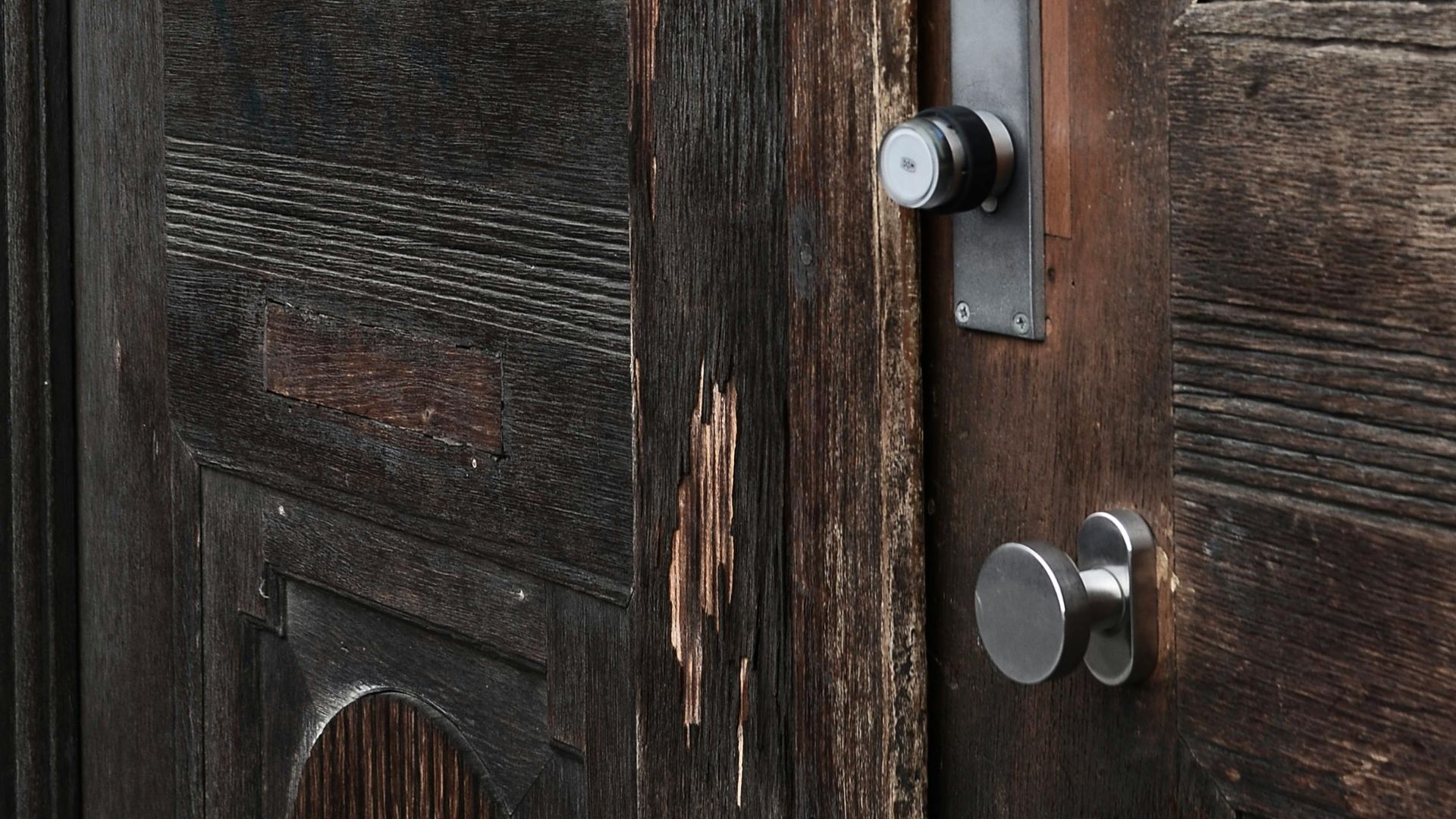 Closed old fashioned doors made of brown wood with damaged surface and metal handles
