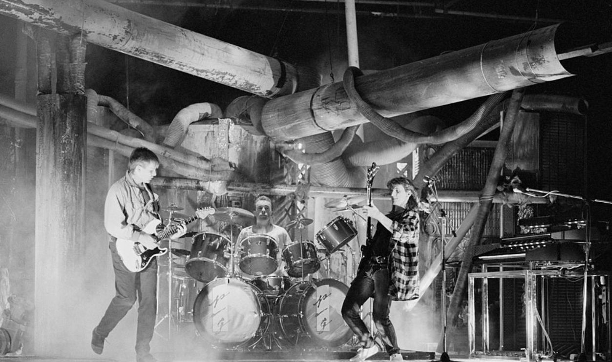 LONDON - 1st APRIL: Rush perform on a video shoot in Battersea, London in April 1984. Left to Right: Alex Lifeson, Neil Peart, Geddy Lee.
