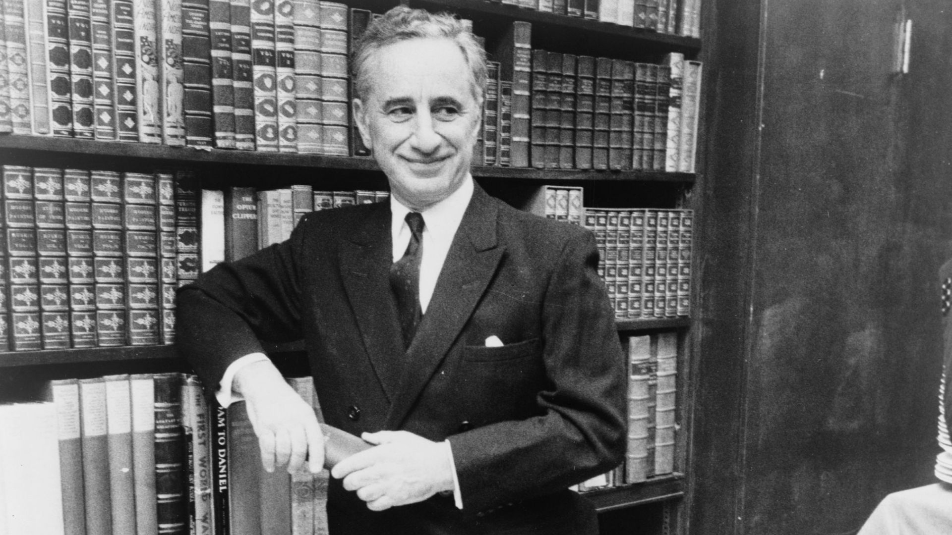 Elia Kazan, full-length portrait, standing before bookshelves at Brentano's book store / World Journal Tribune photo by James Kavallines.