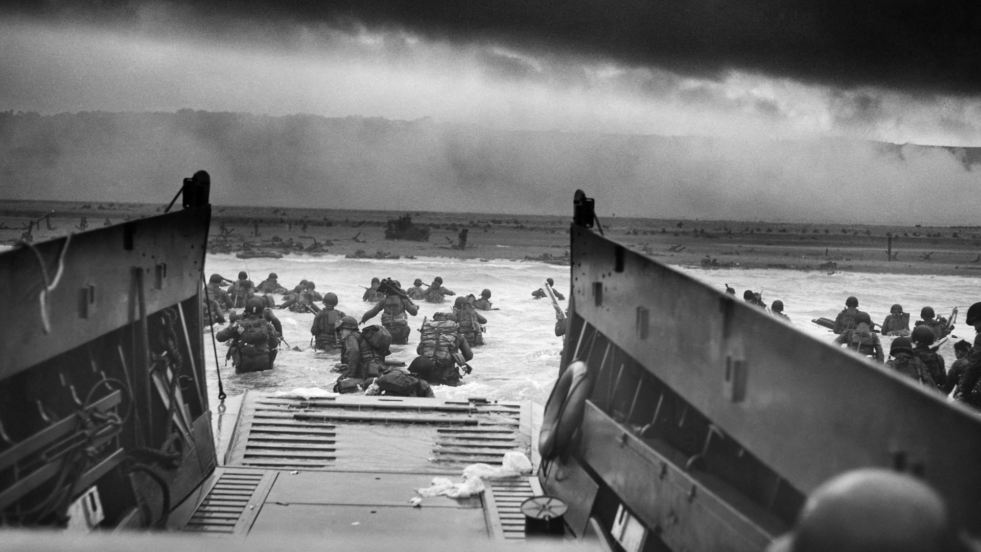 A LCVP (Landing Craft, Vehicle, Personnel) from the U.S. Coast Guard-manned USS Samuel Chase disembarks troops of Company A, 16th Infantry, 1st Infantry Division (the Big Red One) wading onto the Fox Green section of Omaha Beach (Calvados, Basse-Normandie, France) on the morning of June 6, 1944. American soldiers encountered the newly formed German 352nd Division when landing. During the initial landing two-thirds of Company E became casualties.