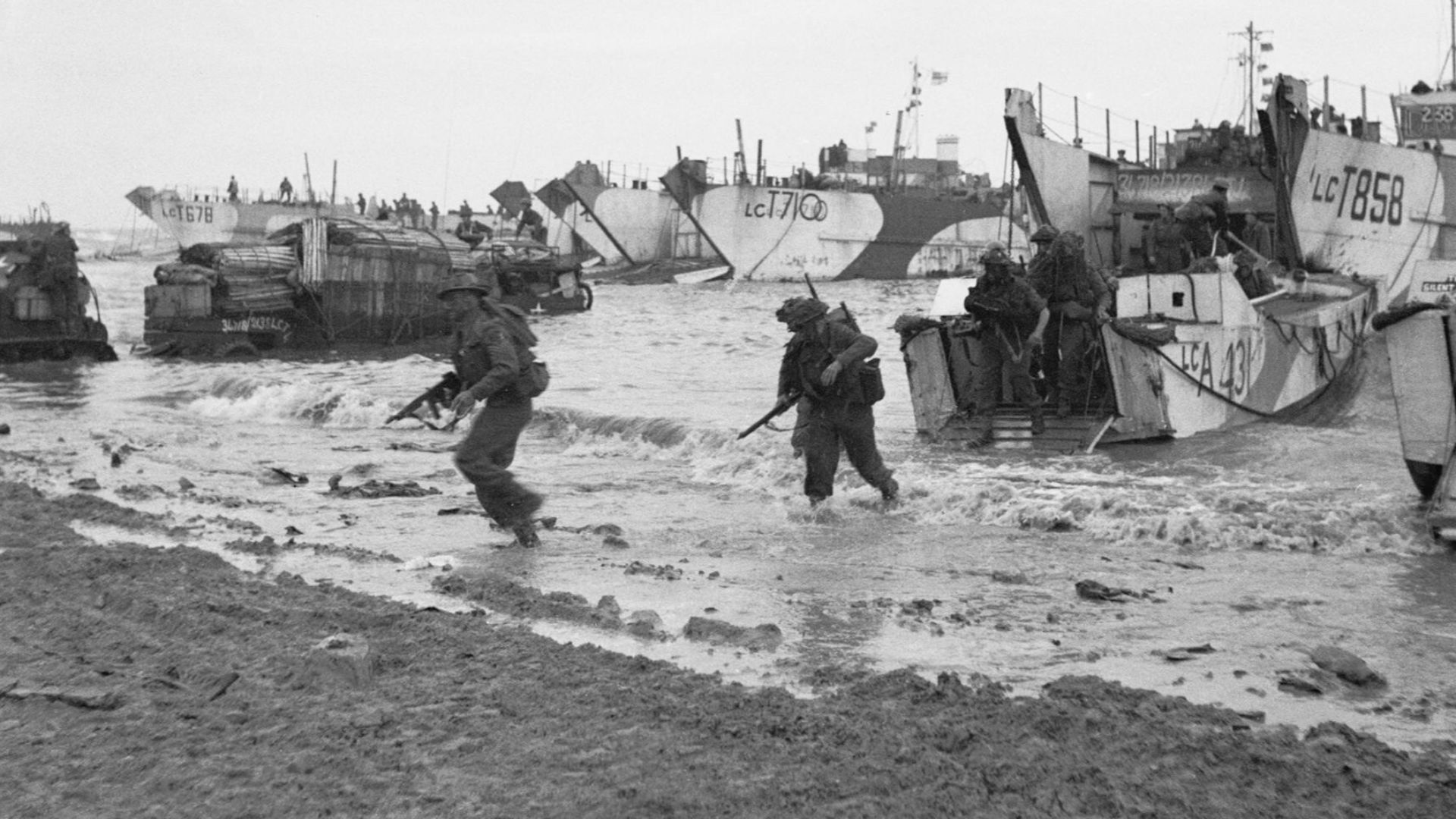 D-day - British Forces during the Invasion of Normandy 6 June 1944
Commandos of 47 (RM) Commando coming ashore from LCAs (Landing Craft Assault) on Jig Green beach, Gold area, 6 June 1944. LCTs can be seen in the background unloading priority vehicles for 231st Brigade, 50th Division.