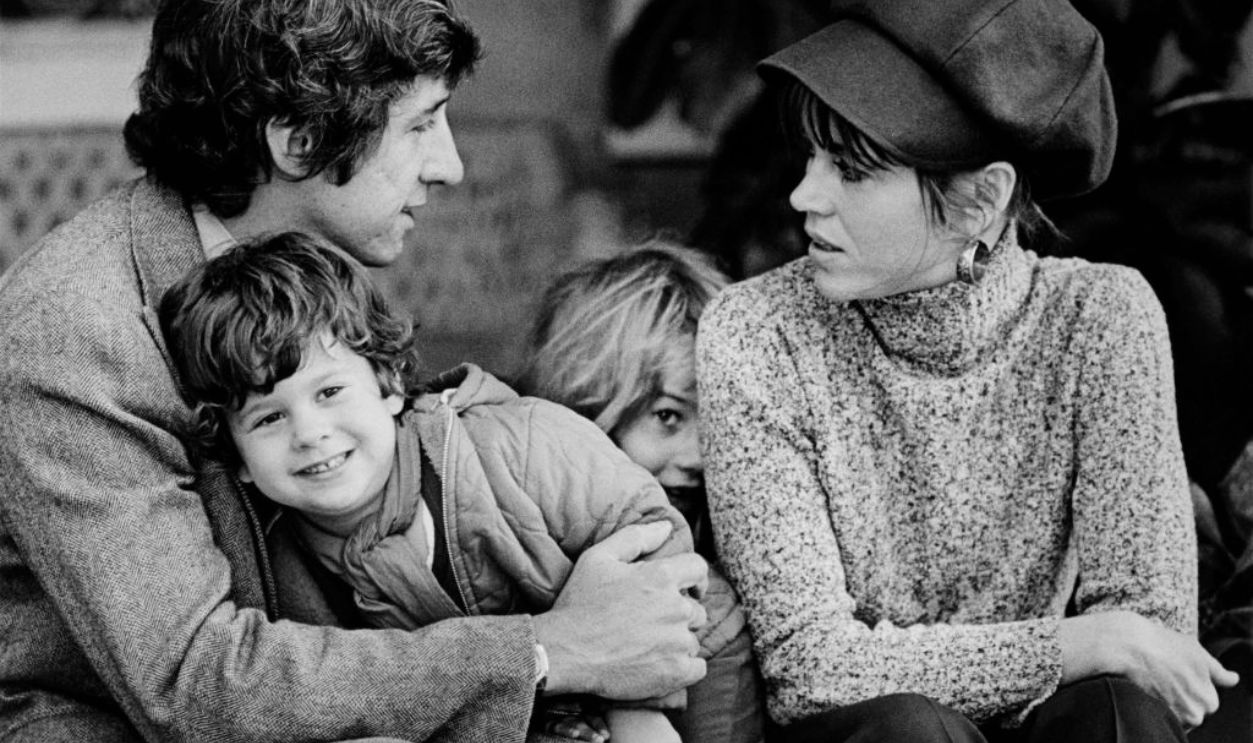SANTA MONICA, CA - 1975: Academy Award-winning actress Jane Fonda poses on the veranda of her home with husband Tom Hayden, son Troy Garity, and daughter Vanessa Vadim (hiding) in this 1975 Santa Monica, California, photo family portrait session. 