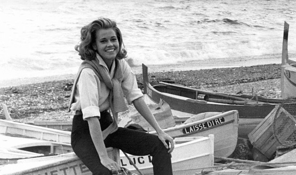 L'actrice américaine Jane Fonda, assise sur une barque de pêche, en bord de mer, en France .
