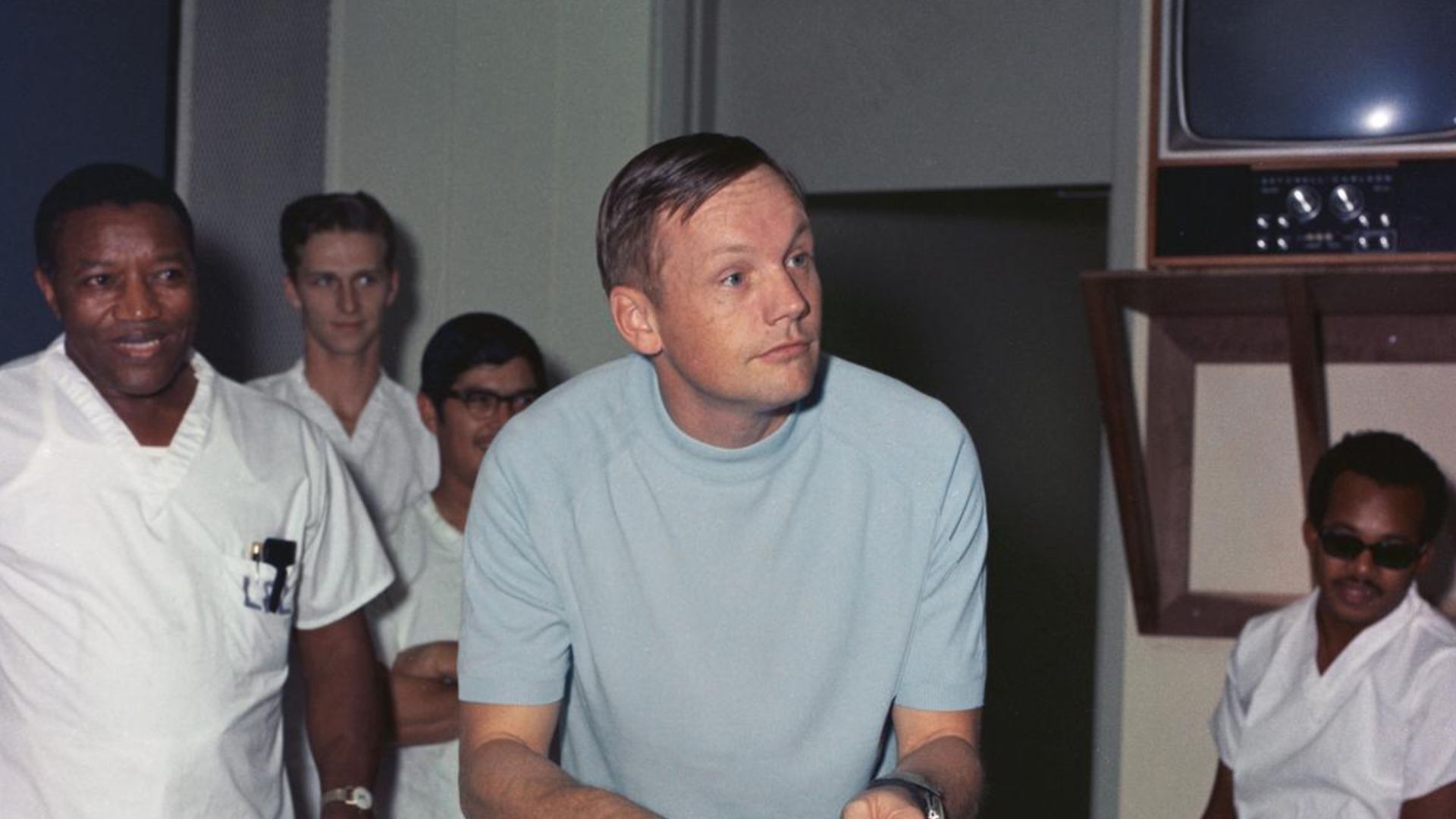 This photograph depicts Neil Armstrong, still in quarantine after returning from the Moon, cutting a birthday cake during a celebration of his 39th birthday.