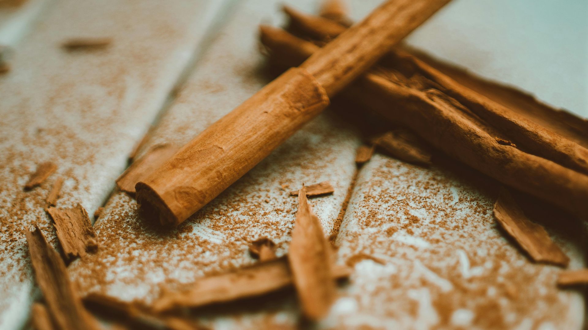 A detailed close-up image of cinnamon sticks and ground cinnamon on a wooden surface, highlighting texture and aroma.
