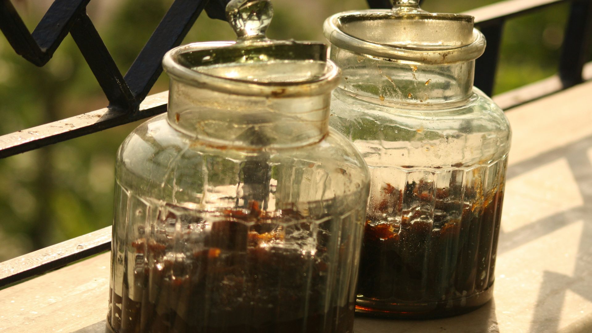 a couple glass jars with brown liquid