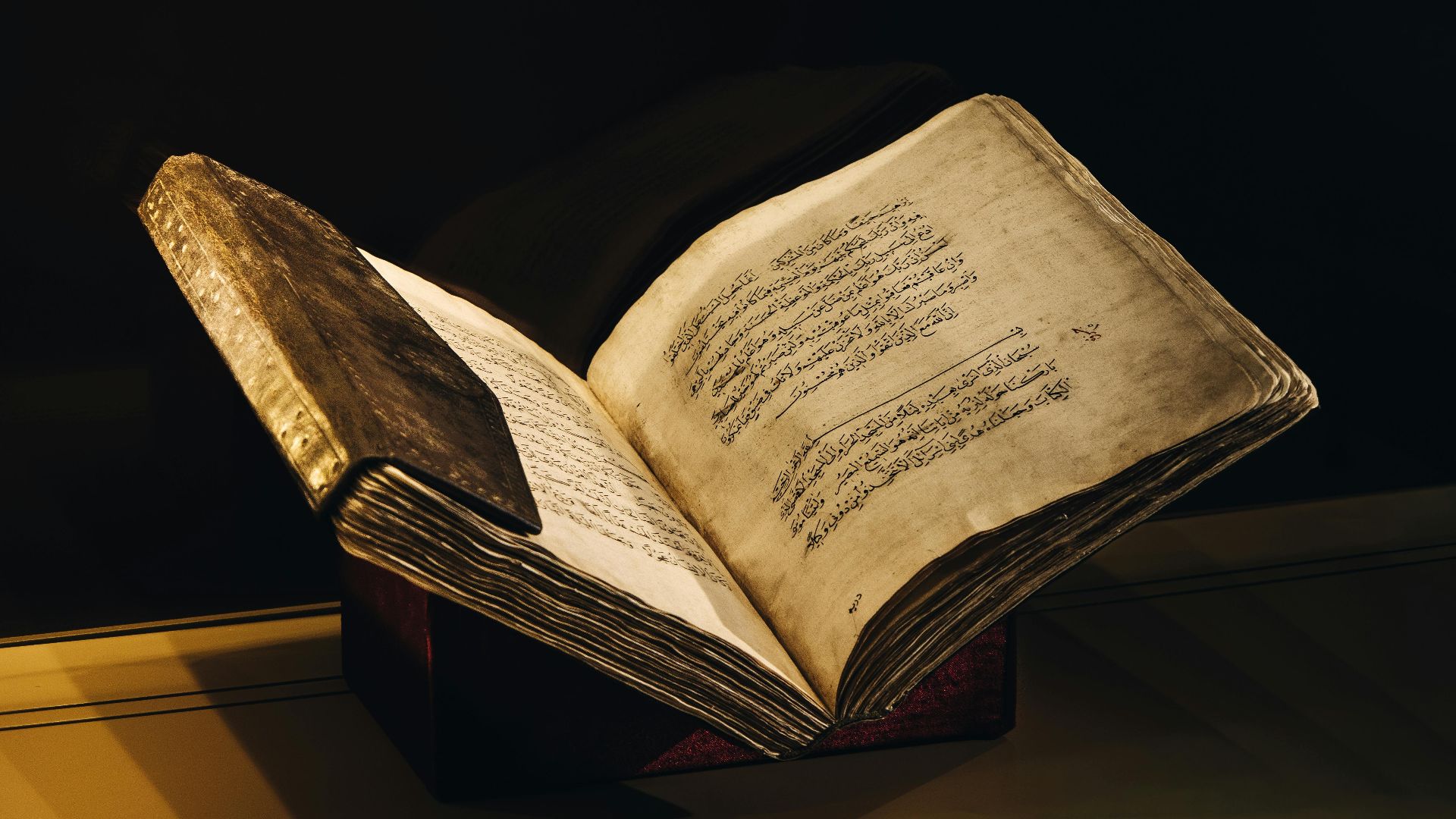 A vintage manuscript with Arabic script open to reveal beautifully aged pages, showcased elegantly.