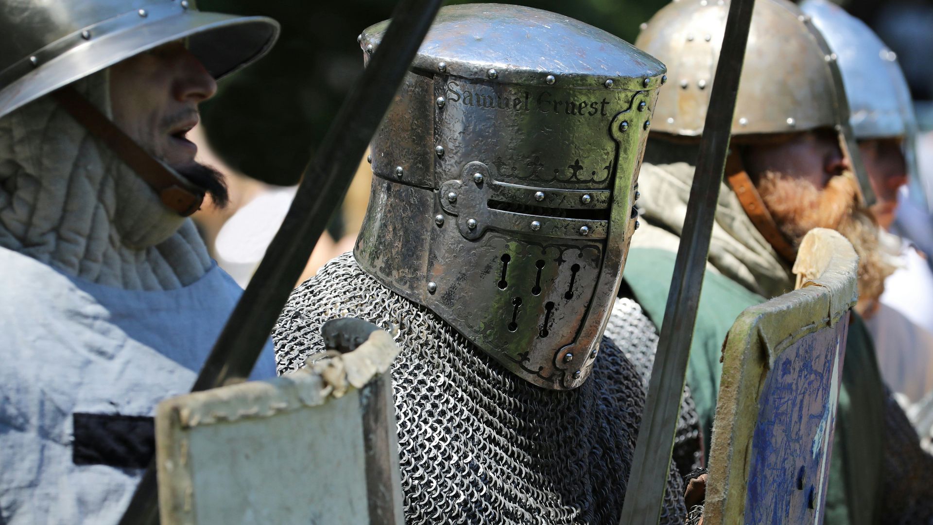 a group of people wearing helmets and holding a large metal object