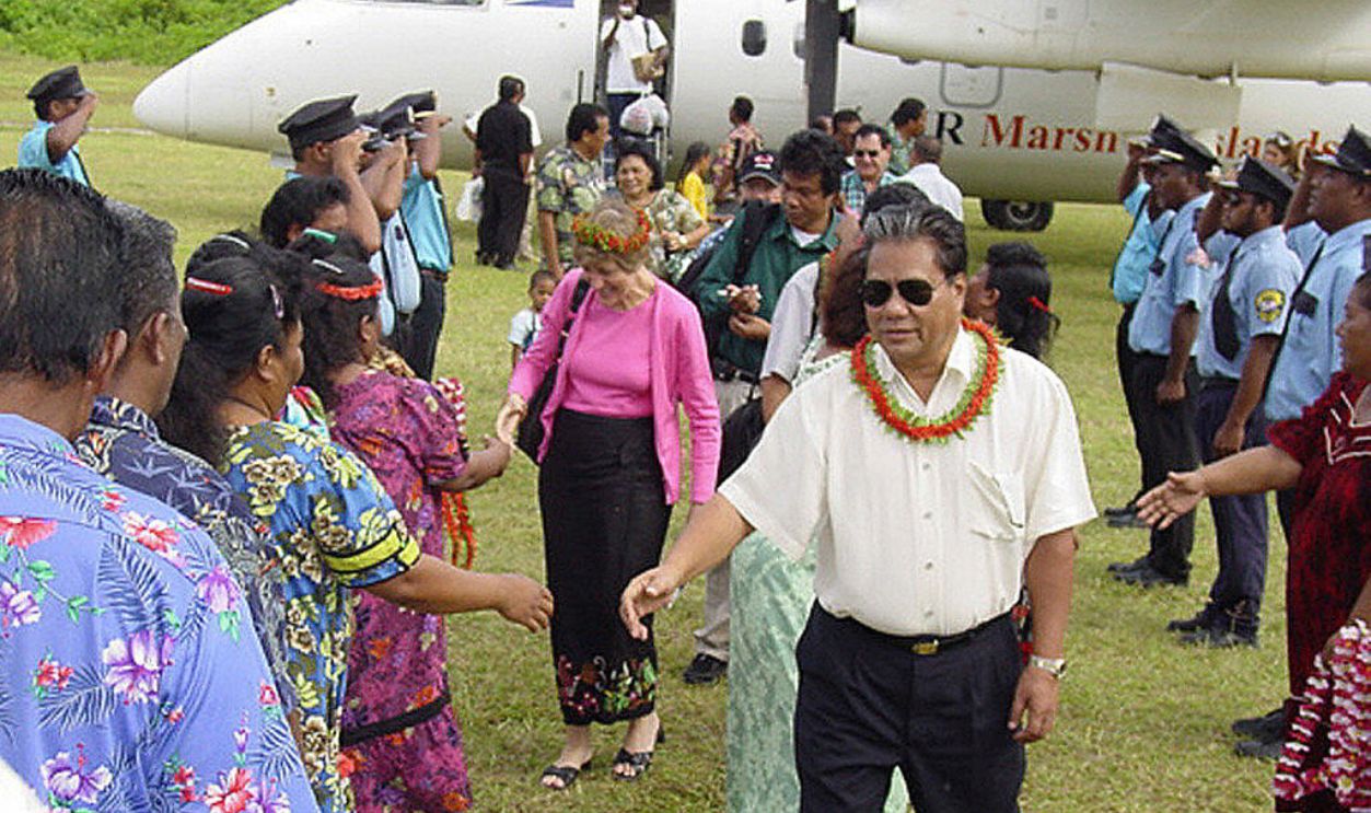  Marshall Islands President Kessai Note (C, white shirt) and US Ambassador Greta Morris (obscured-behind) and other visiting dignitaries being welcomed by Bikinians on Kili, the island where they have lived since the mid-1940s.