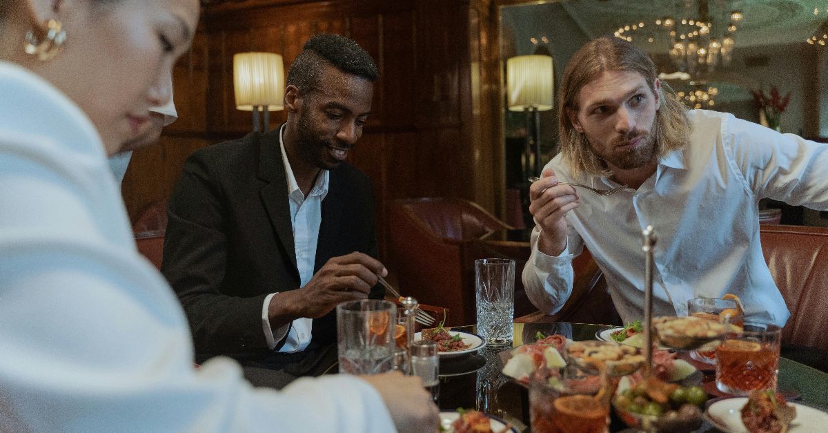 A stylish group enjoying a delicious meal in a sophisticated restaurant setting.