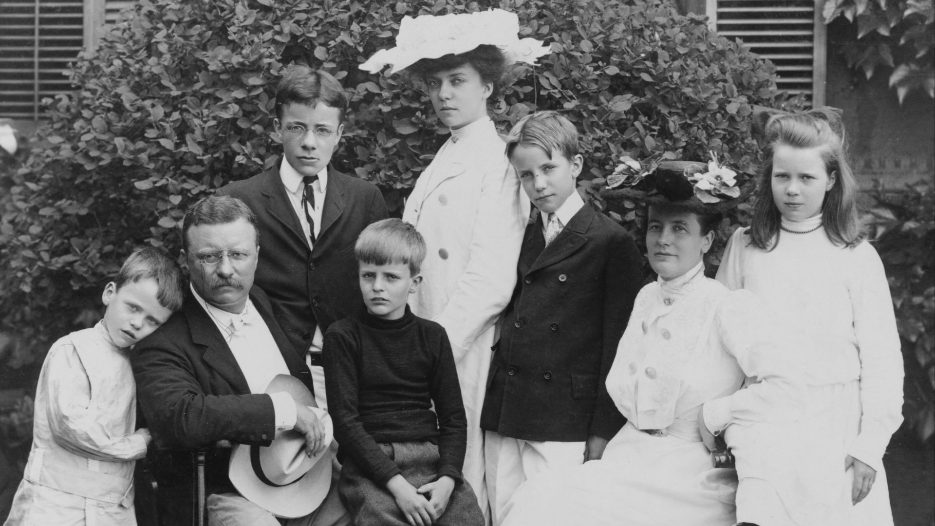 Pres. and Mrs. Theodore Roosevelt seated on lawn, surrounded by their family; 1903.  From left to right: Quentin, Theodore Sr., Theodore Jr., Archie, Alice, Kermit, Edith, and Ethel.