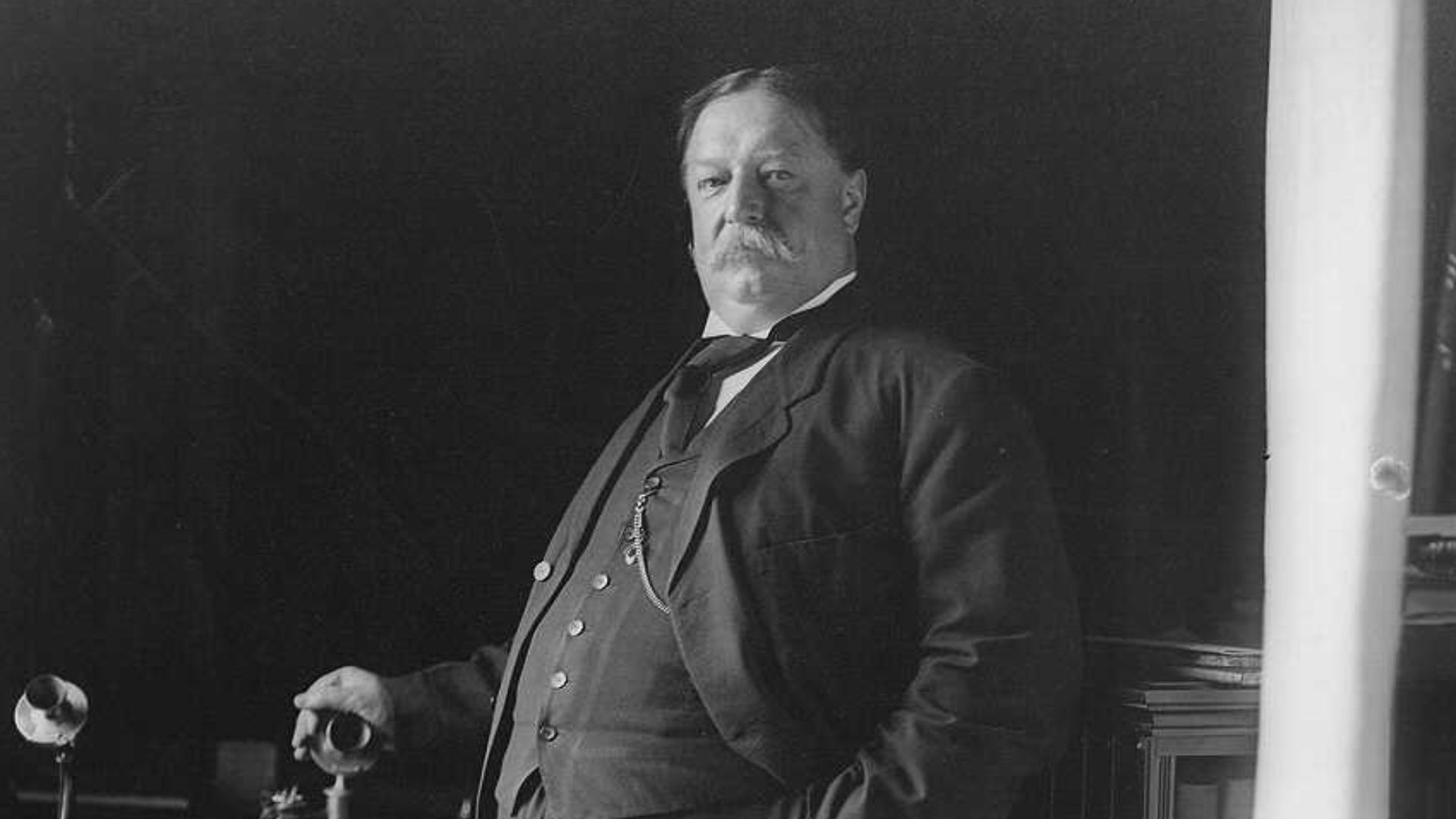 U.S. President William Howard Taft in 1908, posed standing with his hand on a telephone.