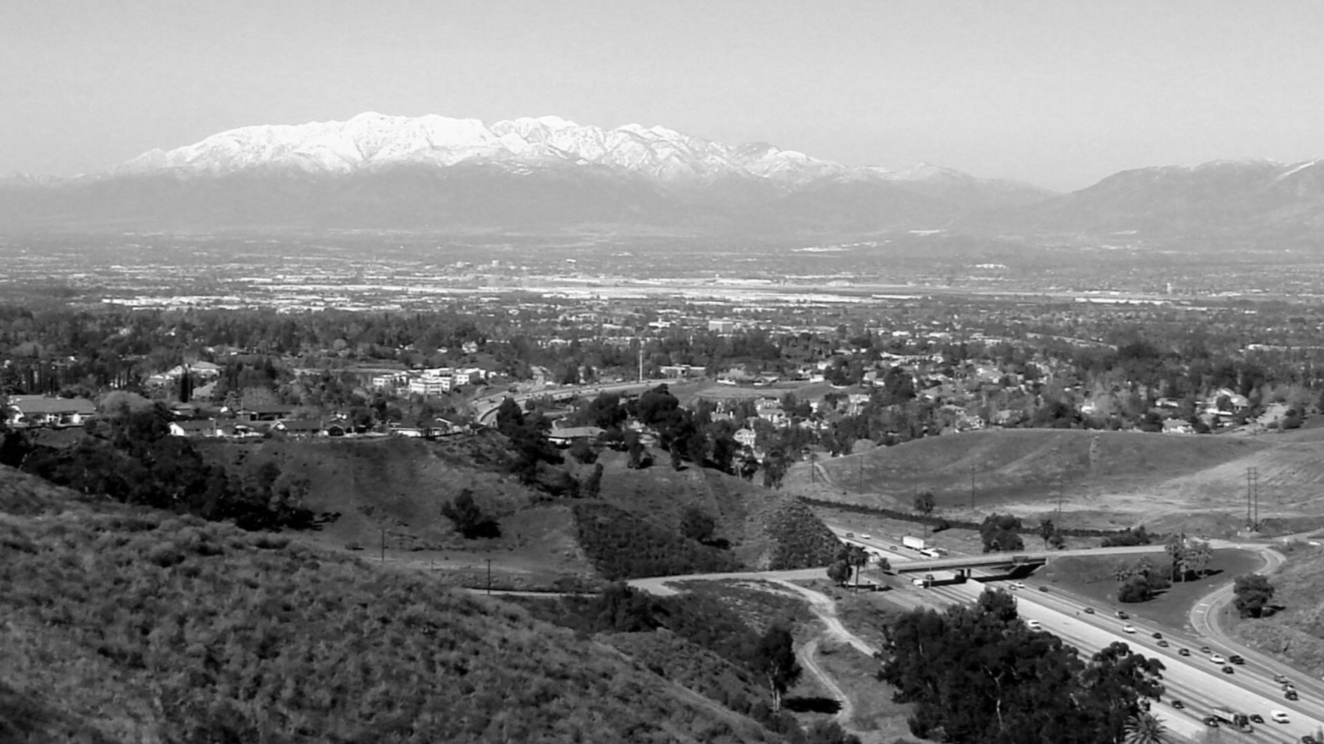 (1 in a 5-picture set)
Mount Baldy lies about 30 miles west of Redlands, California.  When there is snow on the mountain, it shows up from Panorama Point on East Sunset Drive. That is Interstate 10 running through Redlands. One can make out Cajon Pass in the middle-right of the picture which lies between the two mountian ranges. Interstate 15 runs through that to the upper desert.