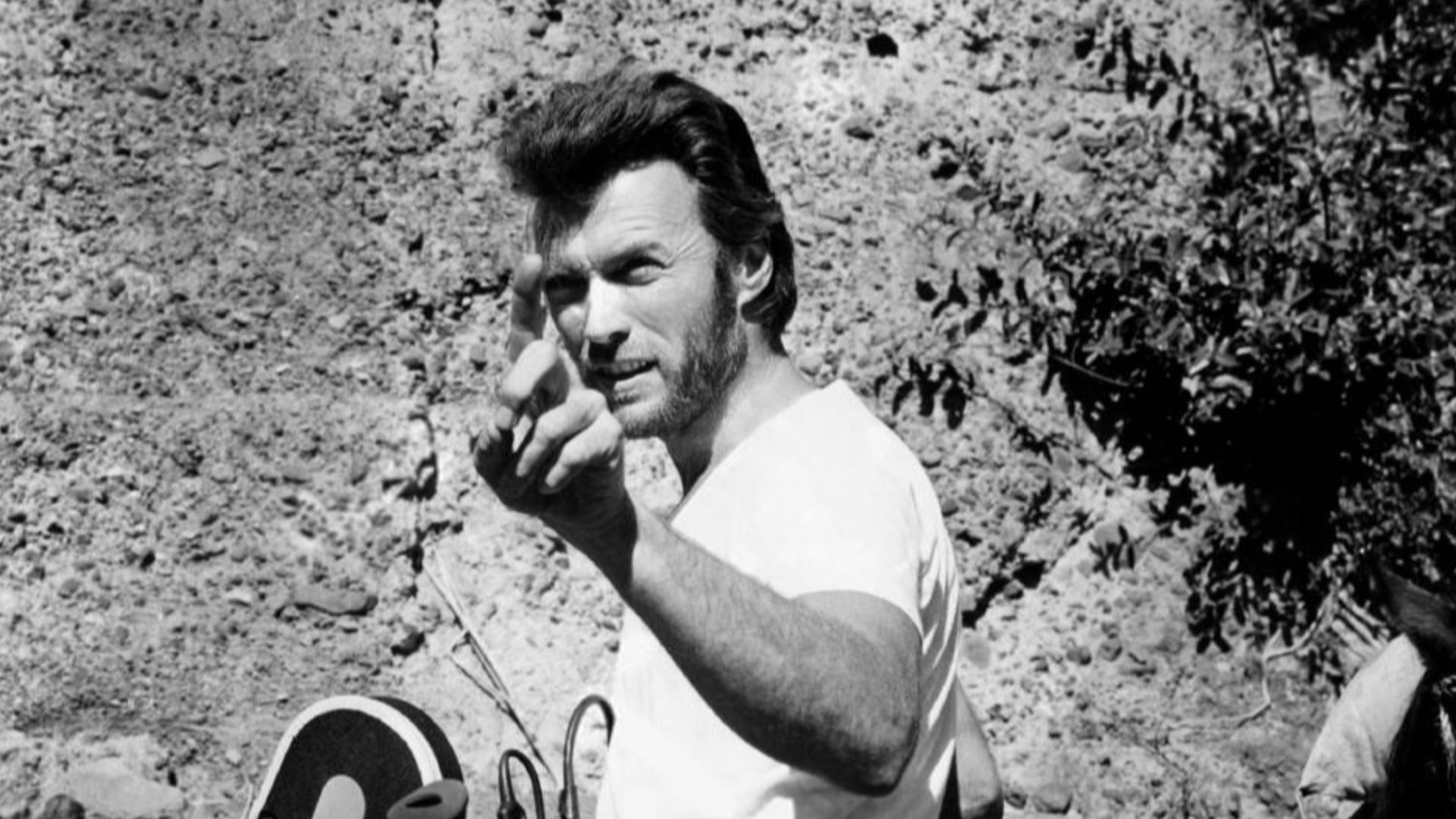 Photograph of Clint Eastwood with a camera during production of the 1970 film Two Mules for Sister Sara, directed by Don Siegel. The film was shot in Mexico in 1969. According to the original caption attached to the backside of the photograph: