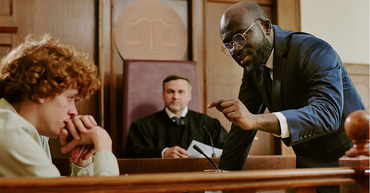 Black middle aged man in suit gesturing while addressing witness