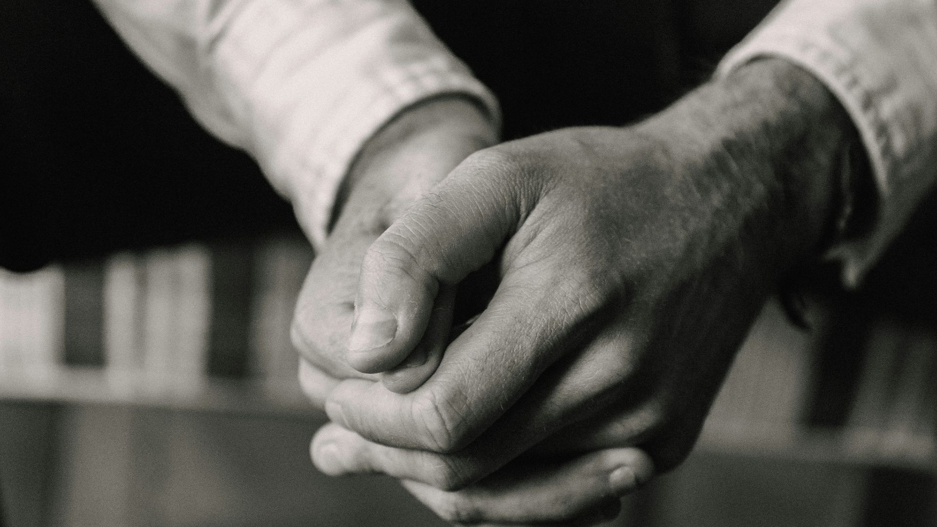 grayscale photo of man and woman holding hands