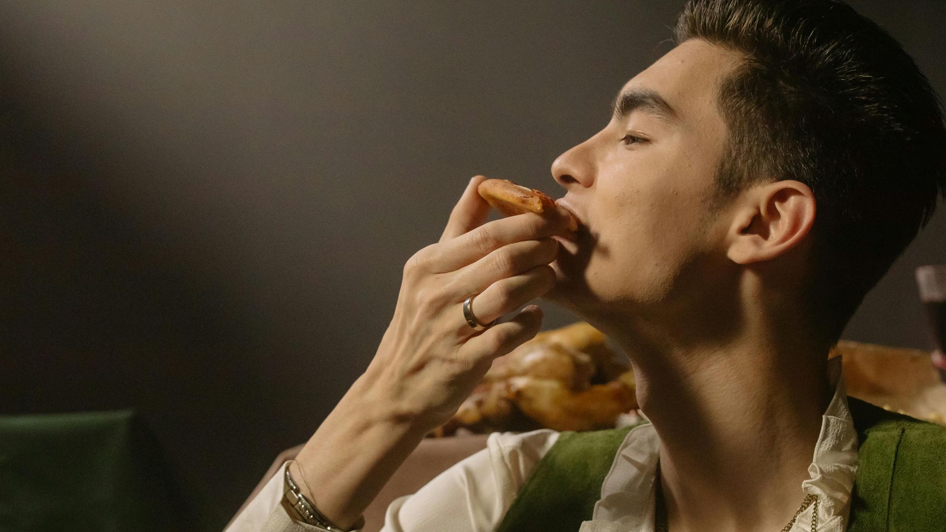A man elegantly savoring a meal in a dimmed, candlelit setting, capturing a baroque style atmosphere.