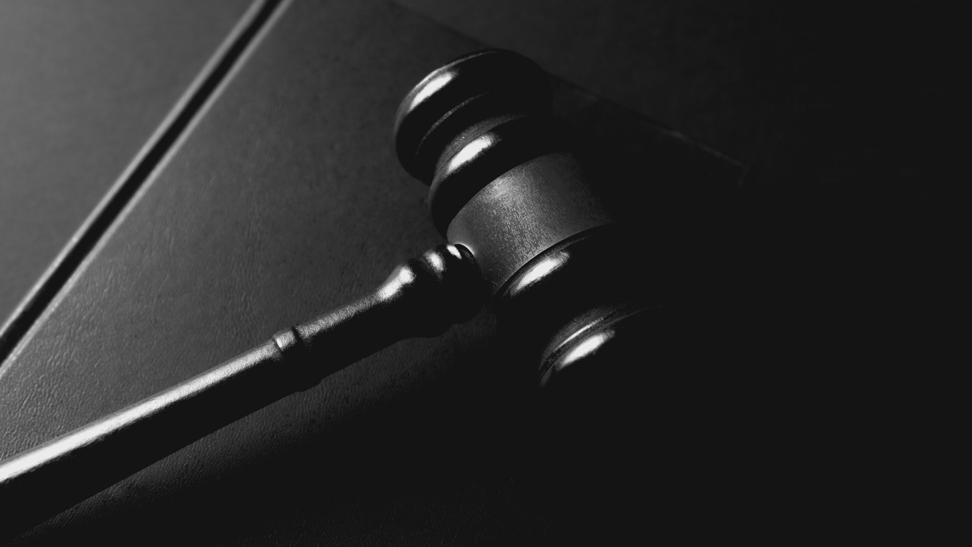 A gavel rests on a dark background.
