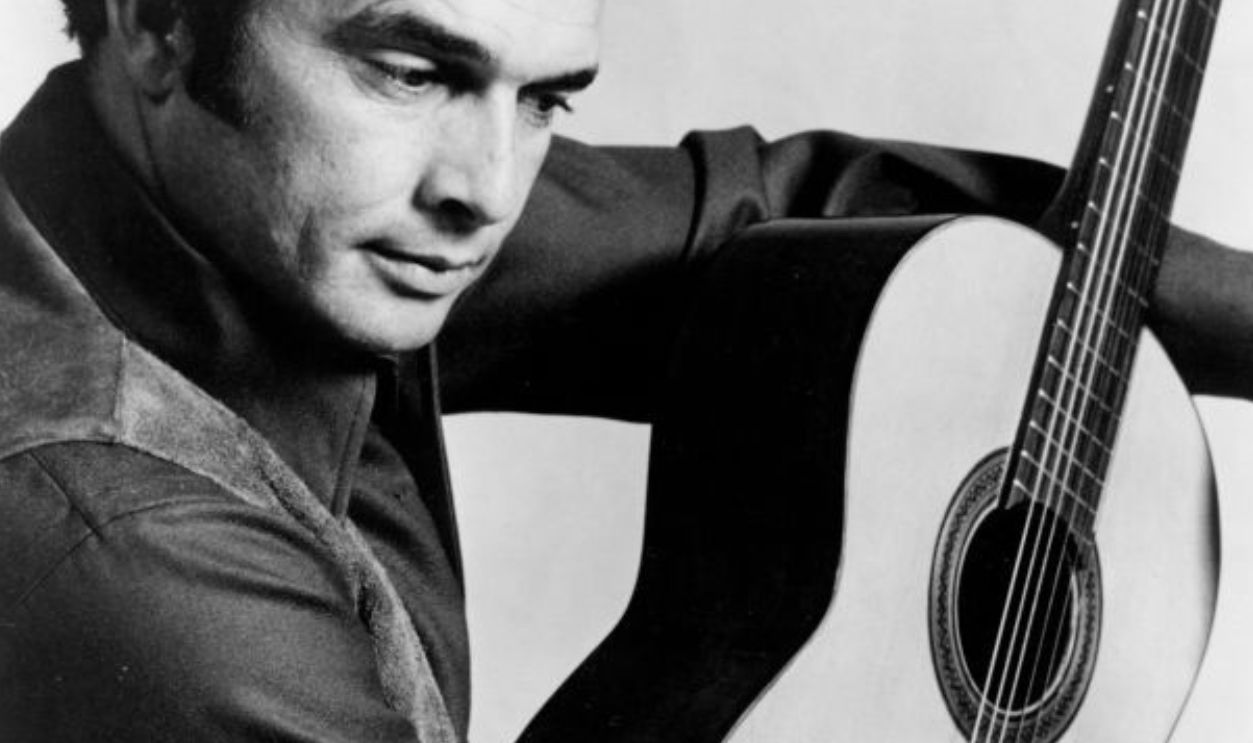 Country musician Merle Haggard poses for a portrait with a guitar circa 1966. 