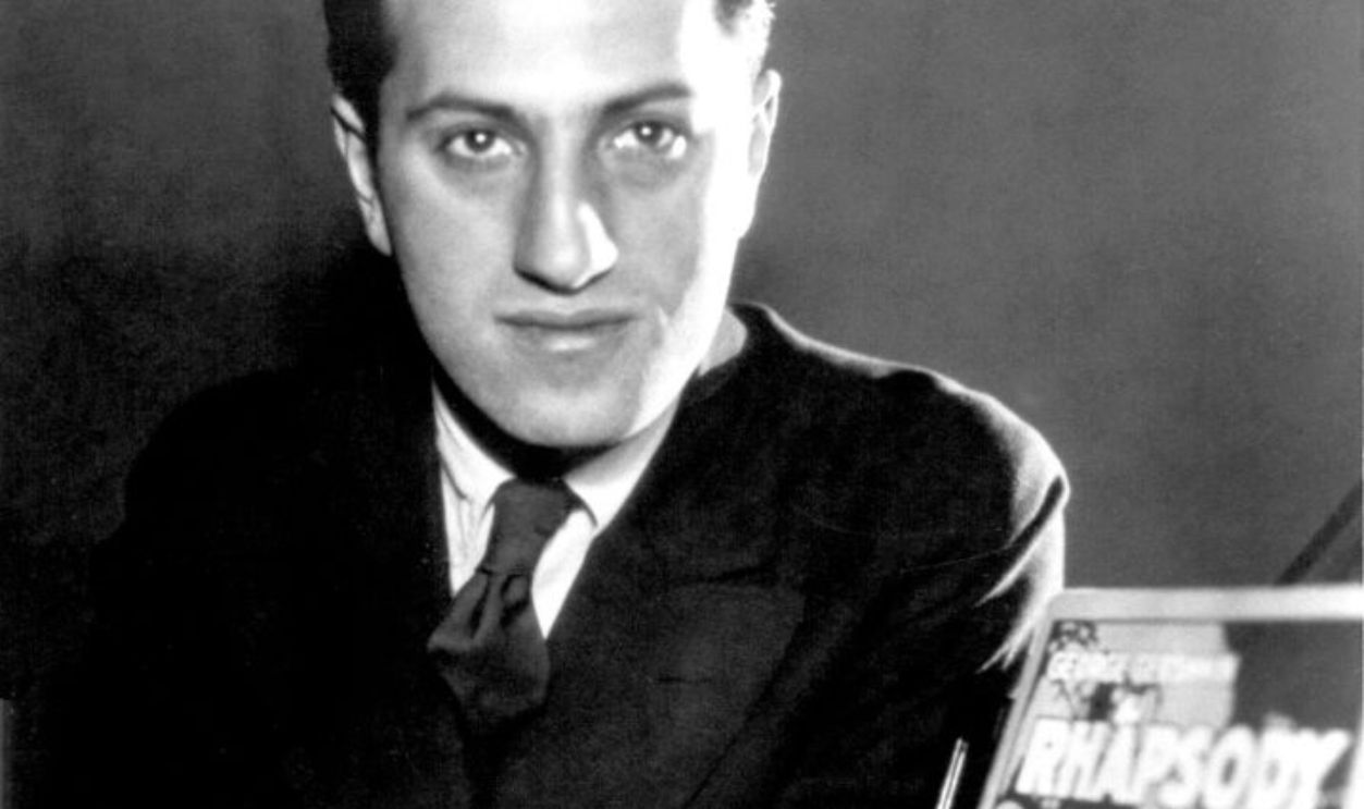 Composer George Gershwin poses for a portrait with the sheet music for 