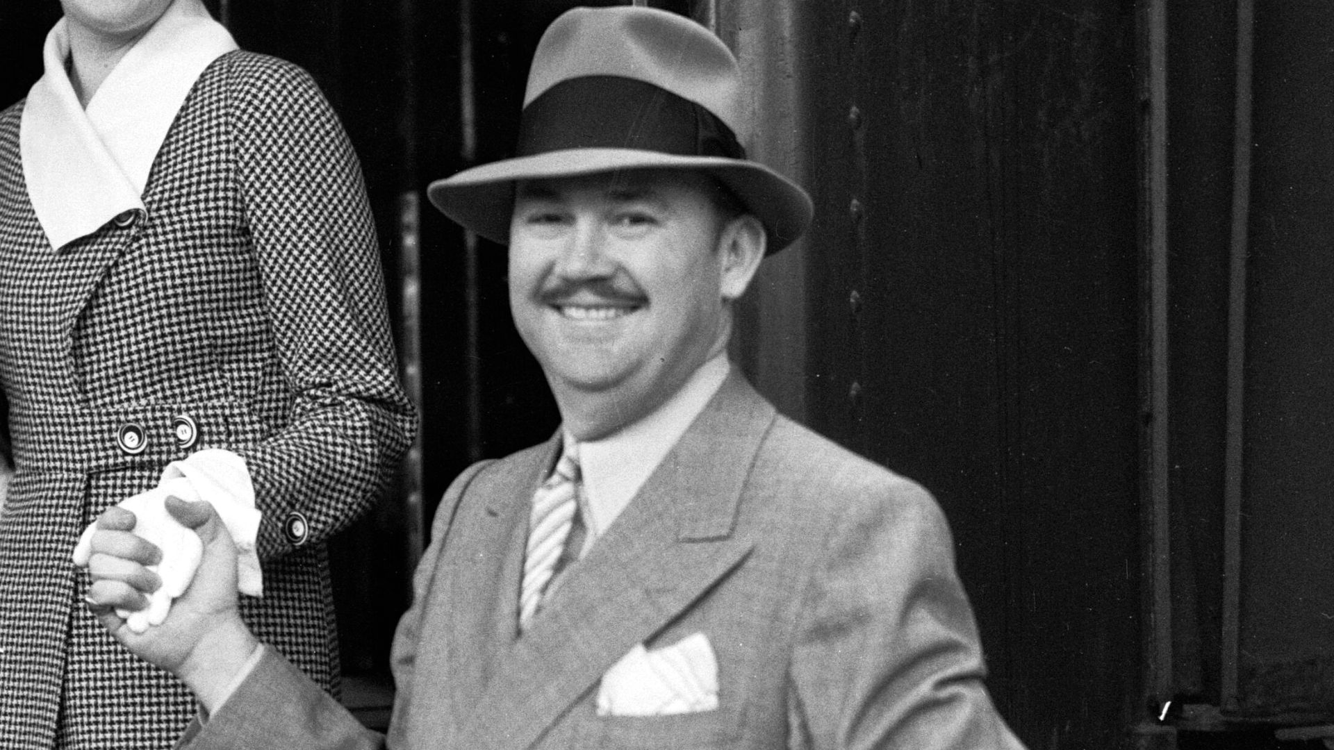 Photograph of jazz band leader Paul Whiteman and his wife, silent film actress Margaret Livingston, stepping out of a train car.