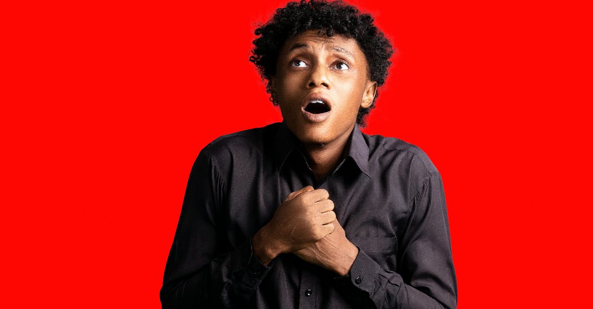 Portrait of a frightened man with open mouth on a red background.