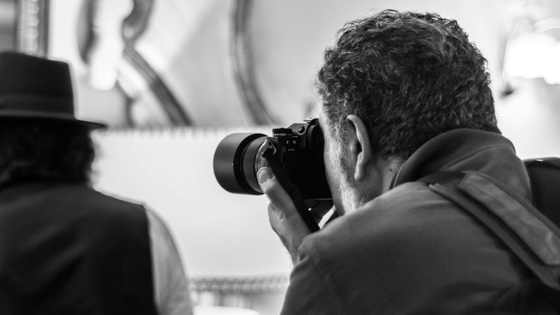 man in black hat taking photo