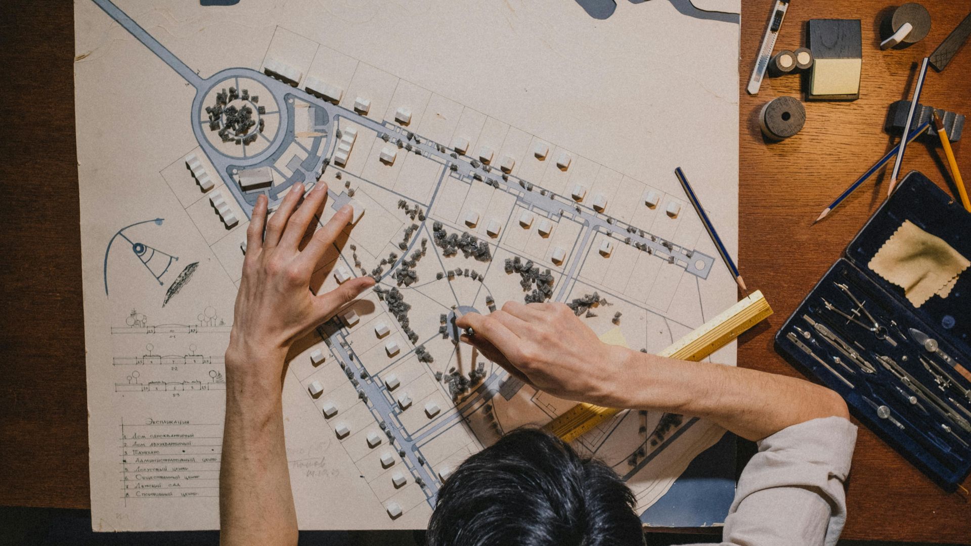 Top view of an architect working on a design project with precision tools.