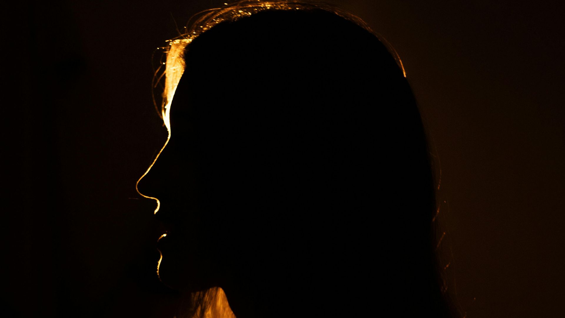 Dramatic silhouette of a woman backlit, creating a captivating glow.