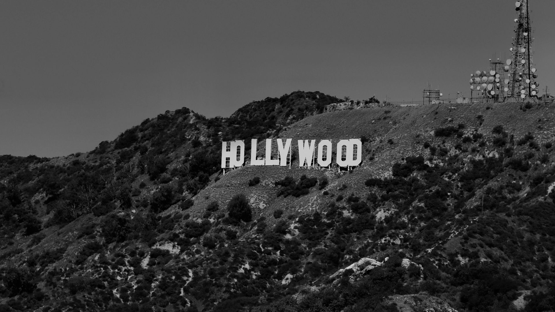 A black and white photo of the Hollywood sign located in the hills of Los Angeles, California.
