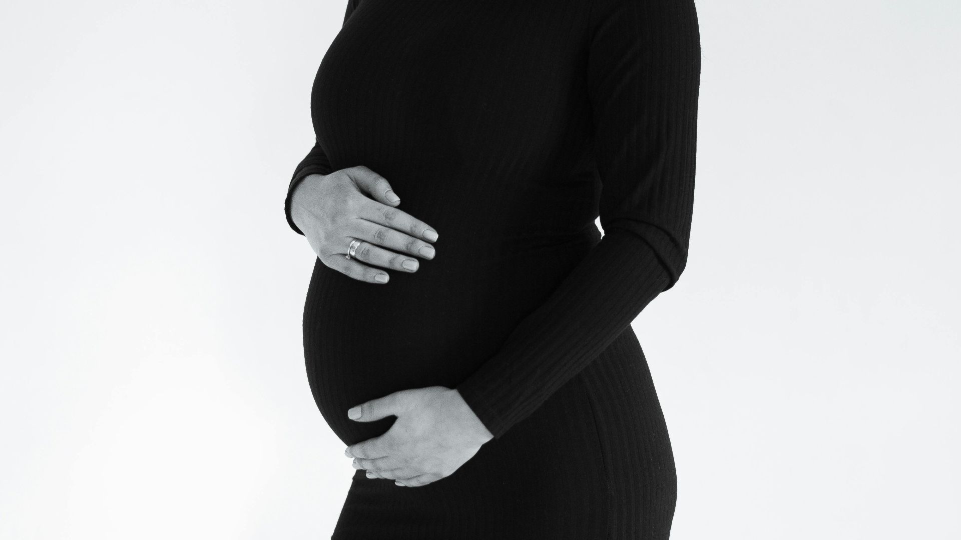 Stylish monochrome portrait of a pregnant woman posing gracefully.