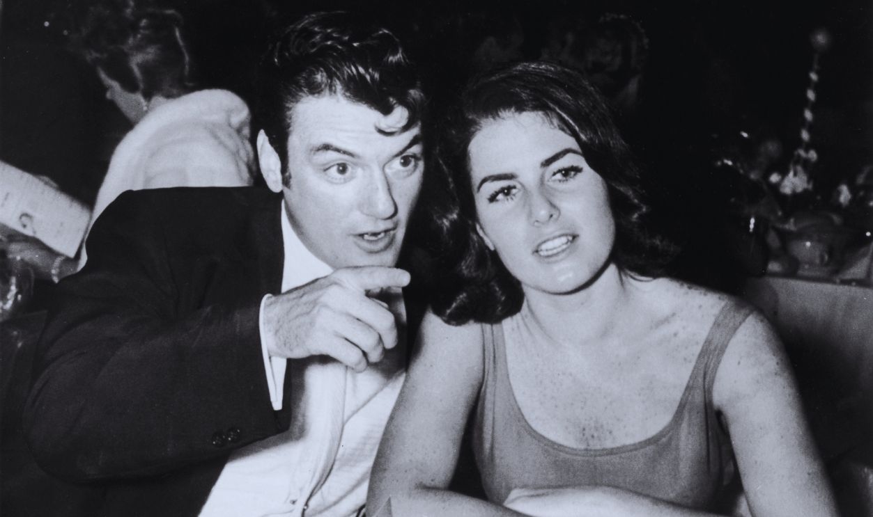 Gettyimages - 3233035, William Campbell circa 1955: American actor William Campbell sits with his wife Judith Exner Campbell at a table, pointing, during the Deb Star Ball. They have cups of coffee in front of them.