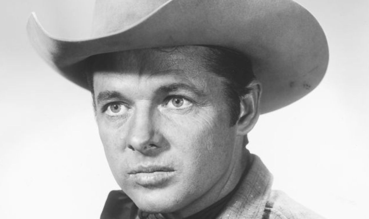 Audie Murphy (1924-1971), US actor, wearing a cowboy hat, Western shirt and neckerchief, in a studio portrait, against a white background, 1955. 
