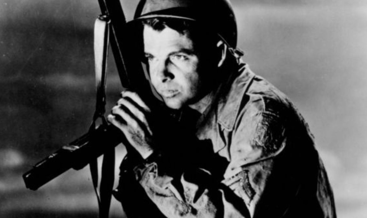 Audie Murphy posing with weapon in publicity portrait for the film 'To Hell And Back', 1955.