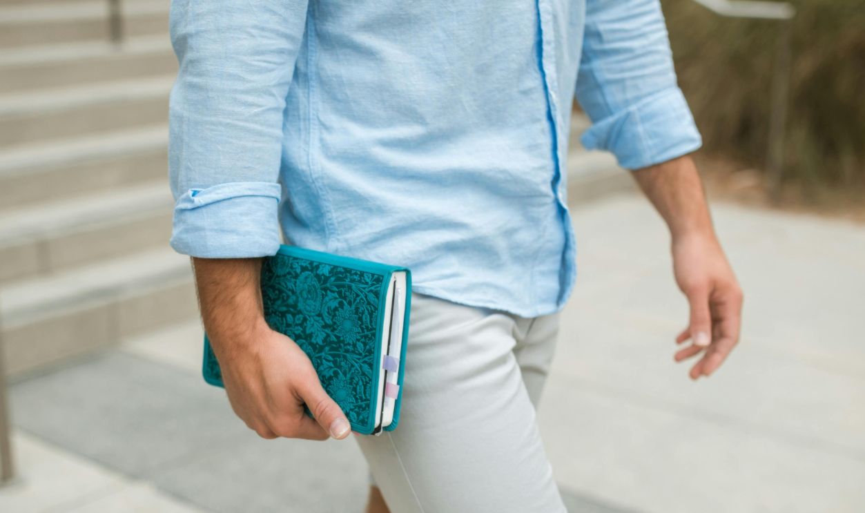 Person in Blue Long Sleeves Carrying a Blue Notebook