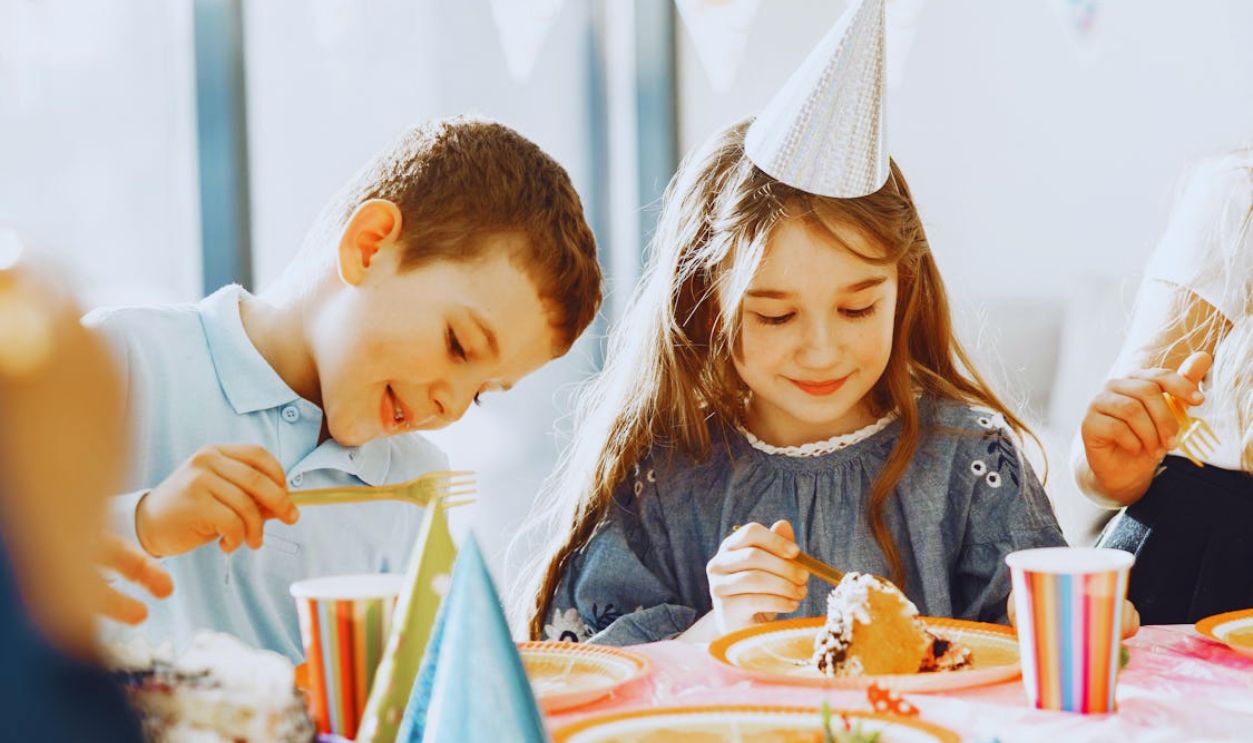 A Boy and a Girl Eating Cake at the Table