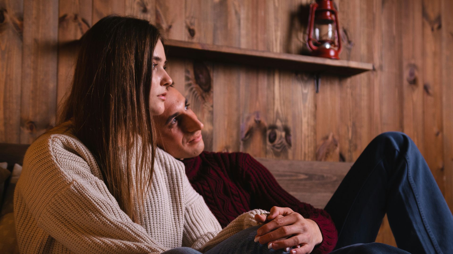 woman in white and black striped long sleeve shirt sitting beside man in black sweater