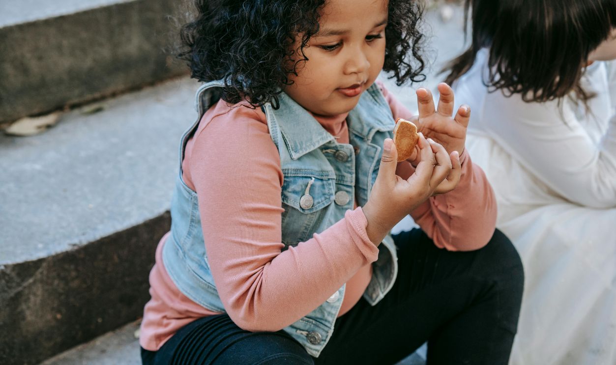 Black girl having gingerbread treat with friend