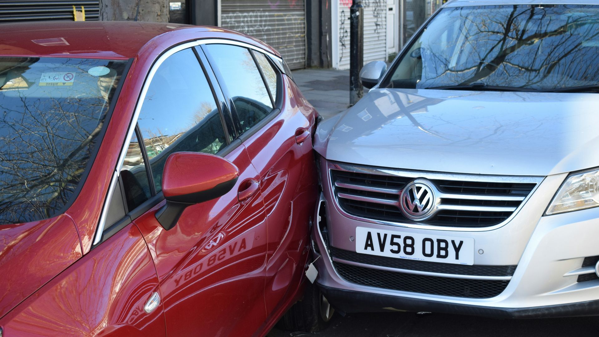 two cars parked next to each other in a parking lot
