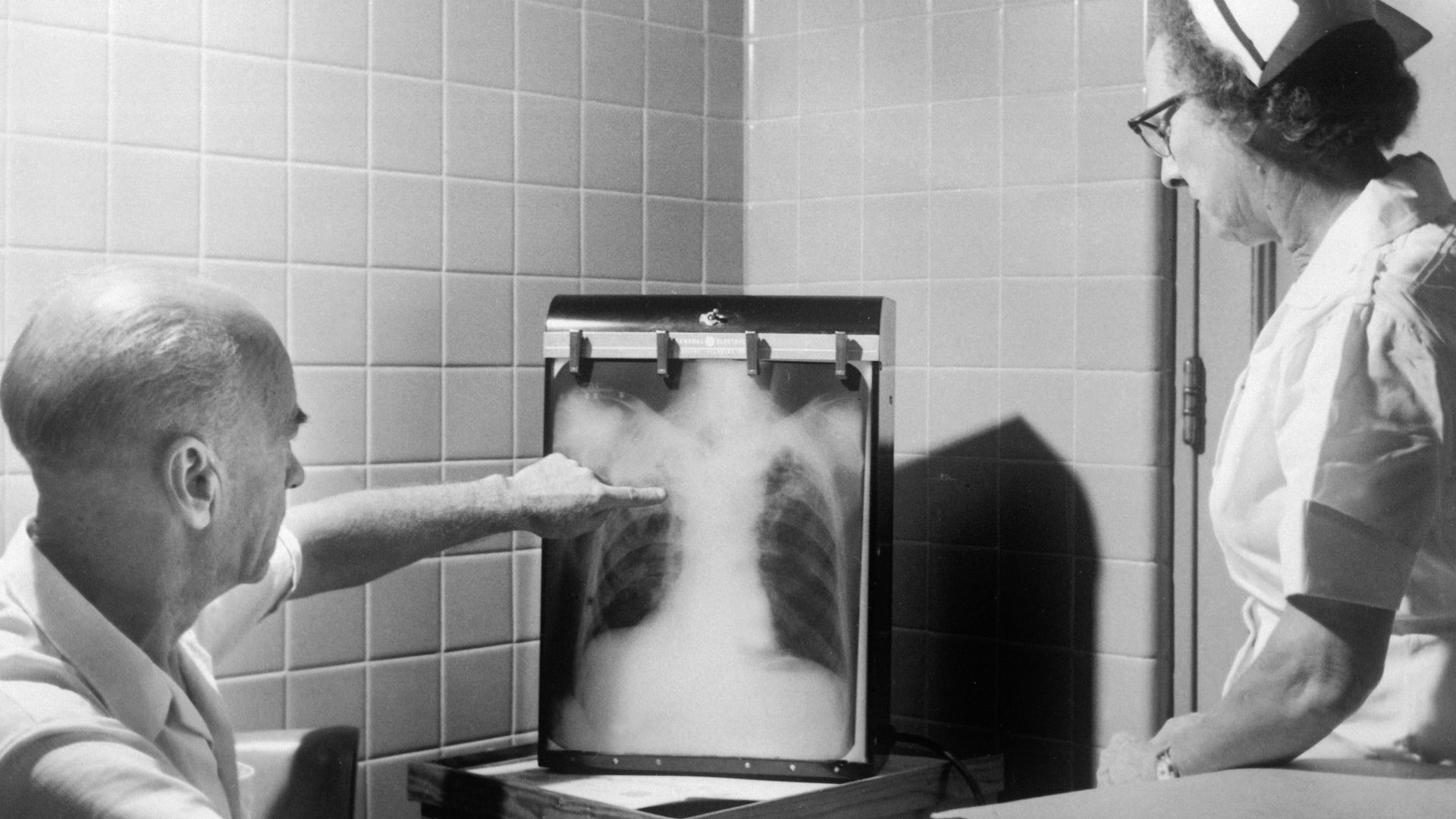 a man and a woman looking at a chest x - ray