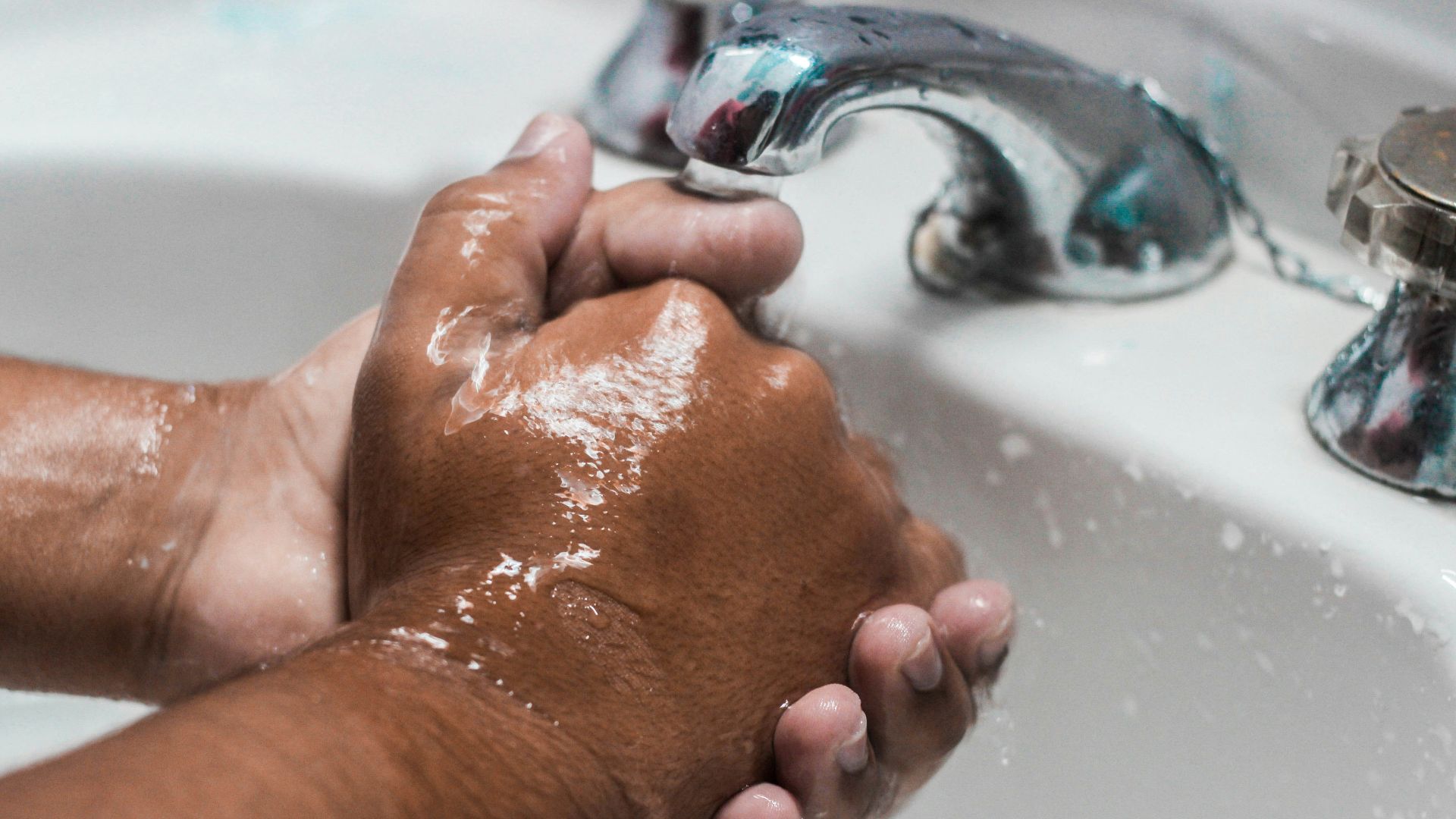 person washing hand on sink