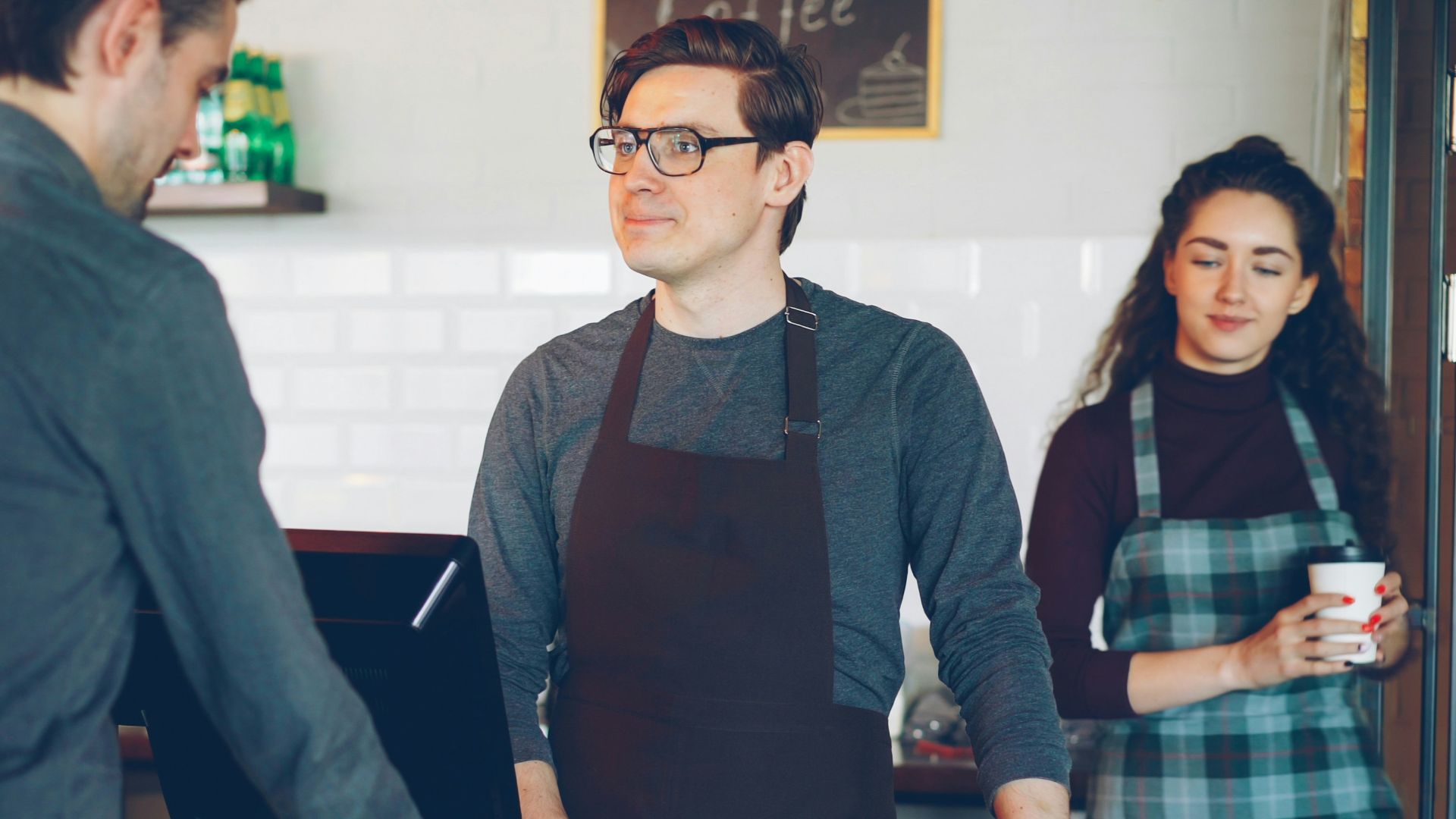 A customer pays at the cafe's counter.