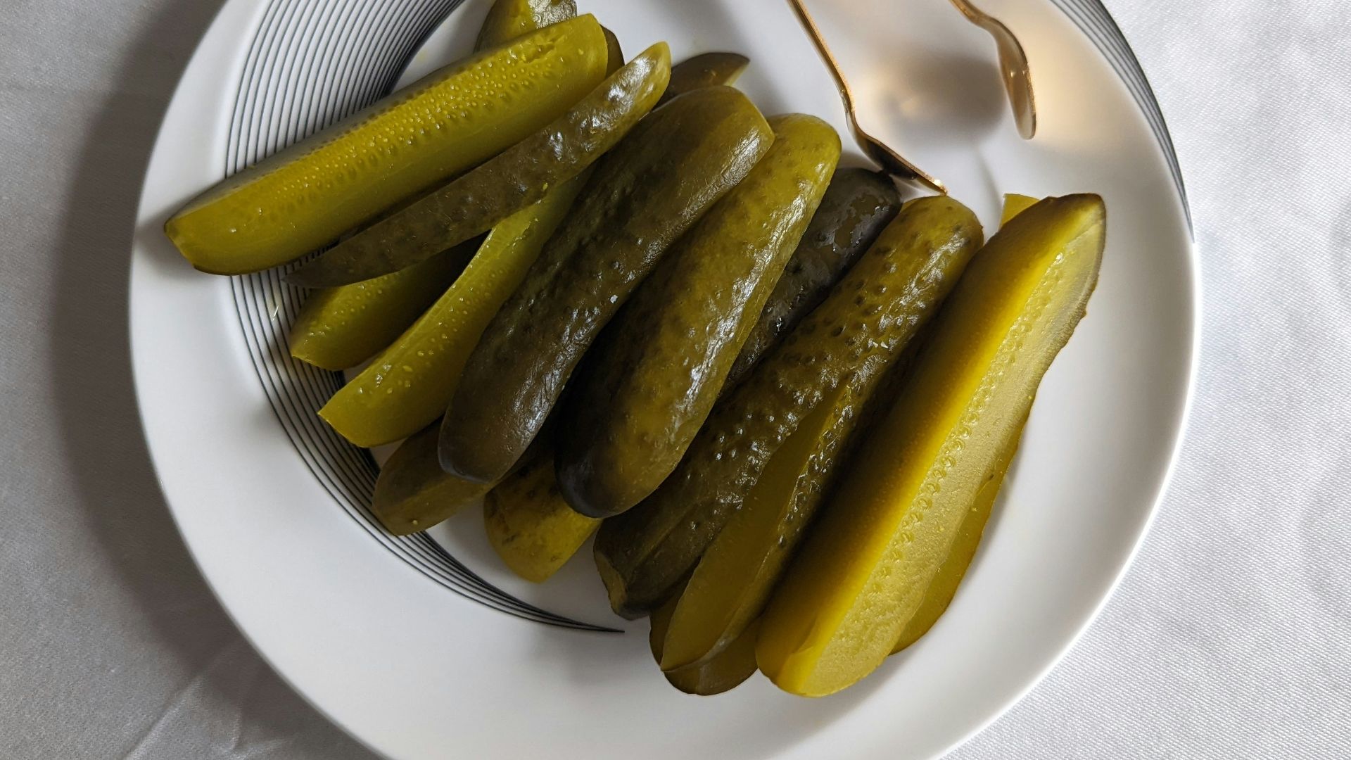 a white plate topped with pickles next to a fork