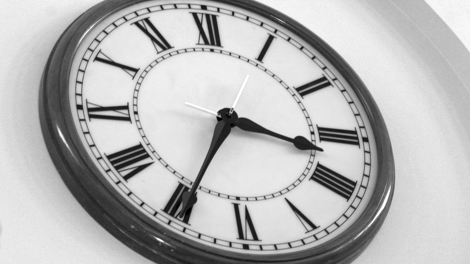 a black and white clock with roman numerals