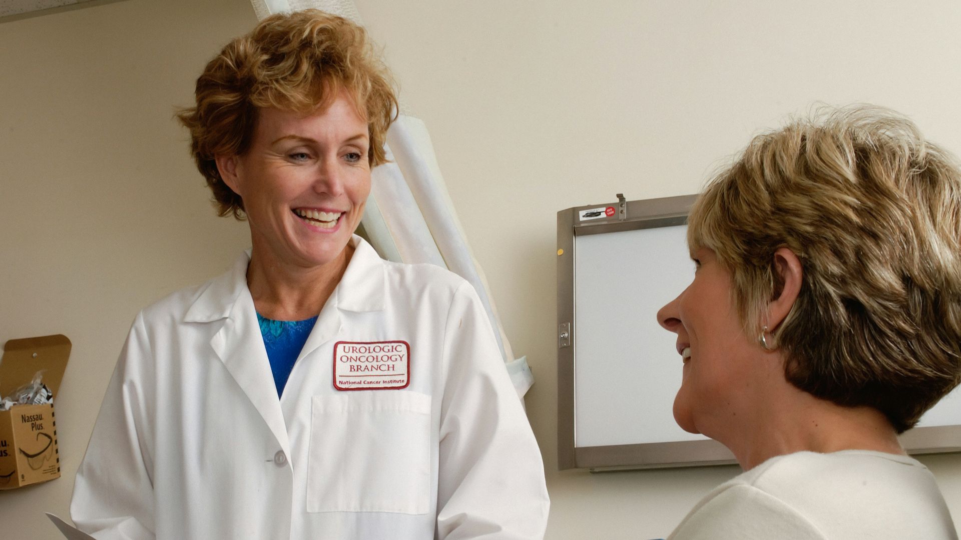 woman in white scrub suit holding gray laptop computer