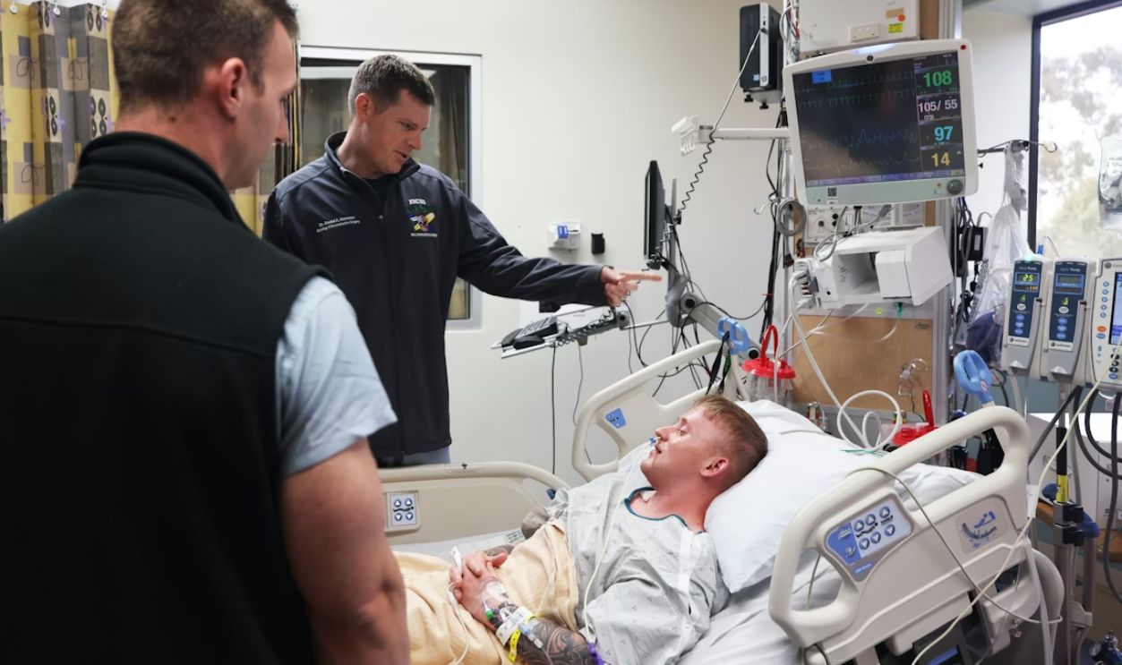 Doctors discuss patient's condition near hospital bed.