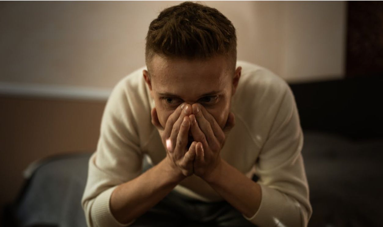 Man in White Long Sleeves Covering Face