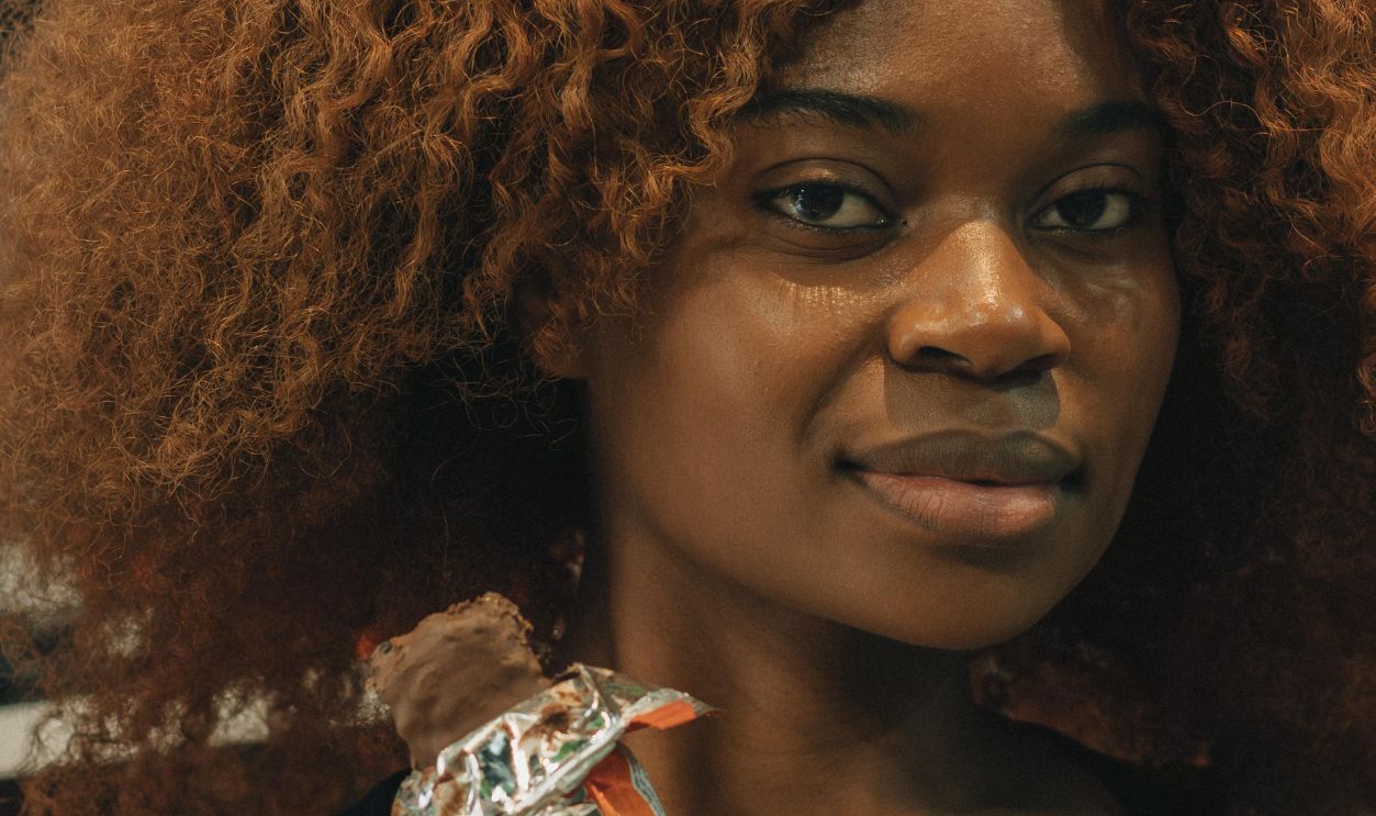 Woman Enjoying a Chocolate Bar Indoors
